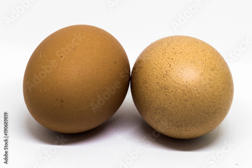 Two fresh chicken eggs with brown shell on white background photo