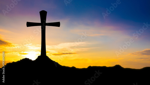 Cross on a hill at sunset photo