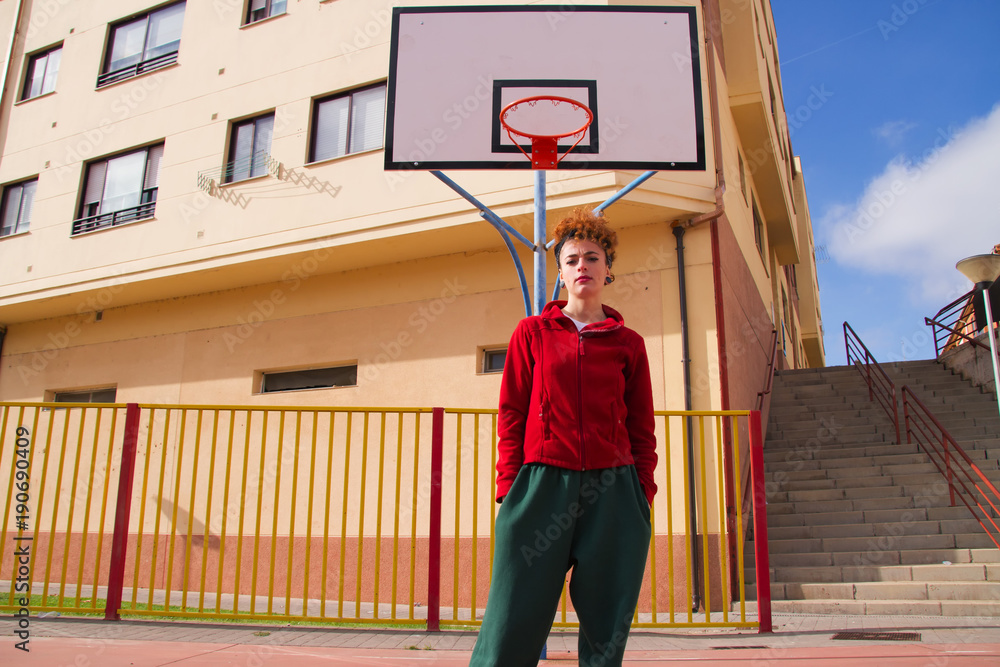 Fototapeta premium Mujer joven en una cancha de baloncesto urbana 