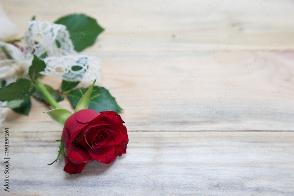 Red rose with beautiful lace ribbon on wooden background, Valentine's day.
