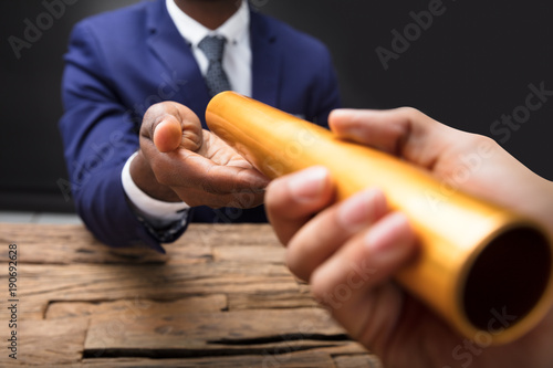 Businessman Passing Baton To His Partner