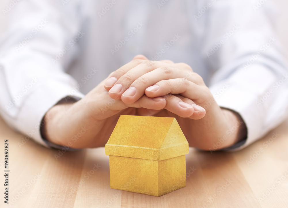 Small yellow house protected by hands Small yellow house protected by hands