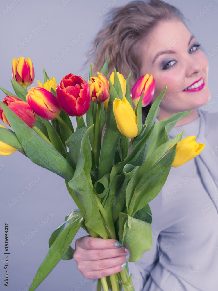Pretty woman with red yellow tulips bunch Pretty woman with red yellow tulips bunch