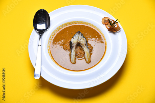 Cream soup or puree in brown color on yellow background