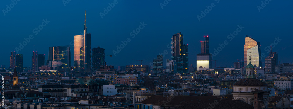 Obraz premium Mediolan (Włochy) nocą; pejzaż miejski z nowymi drapaczami chmur Porta Nuova, panoramiczny widok z dachu katedry Duomo w Mediolanie.