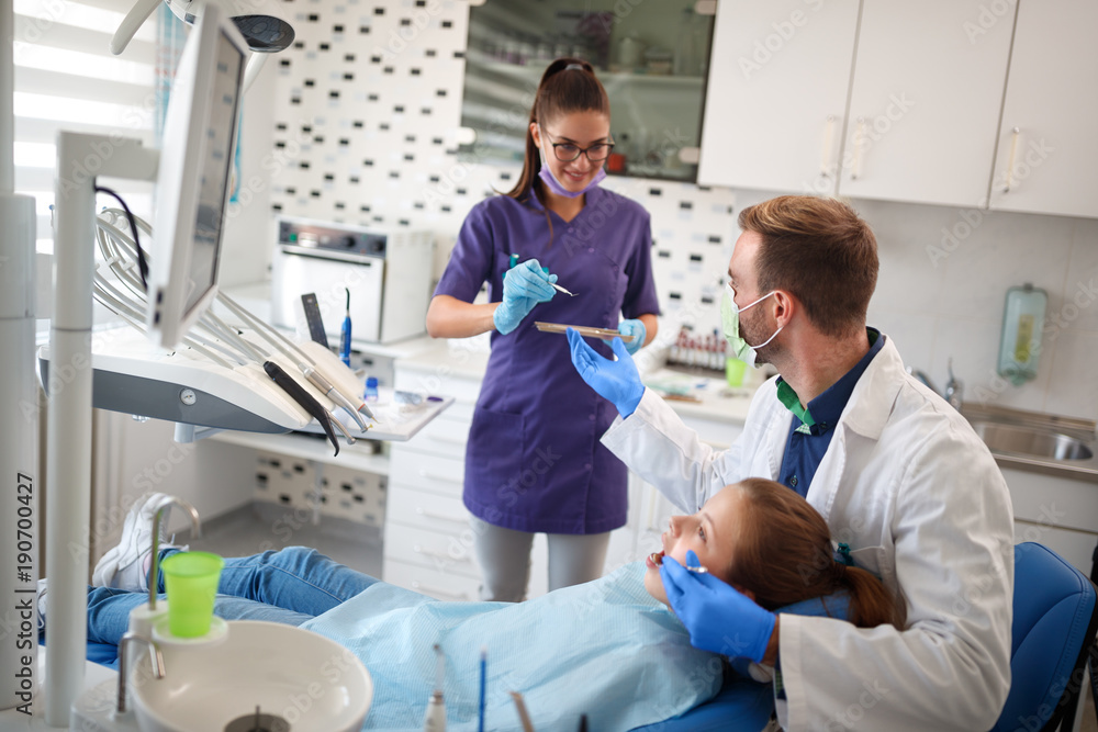Dental ordination with patient in dental chair with doctor and assistant Dental ordination with patient in dental chair with doctor and assistant
