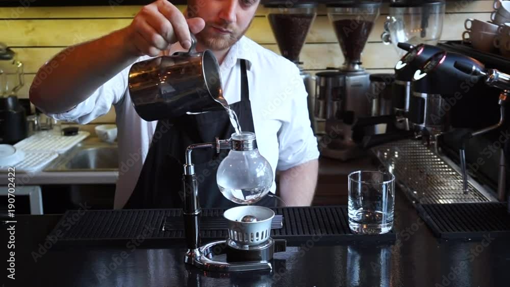Close up barista pouring Syphon coffee into glass in coffee shop Close up barista pouring Syphon coffee into glass in coffee shop