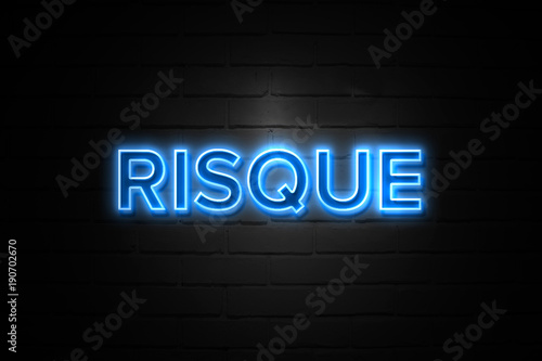 Risque neon Sign on brickwall