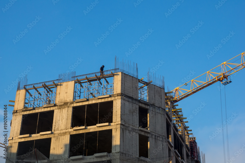 the builder is on the roof of a house under construction the builder is on the roof of a house under construction