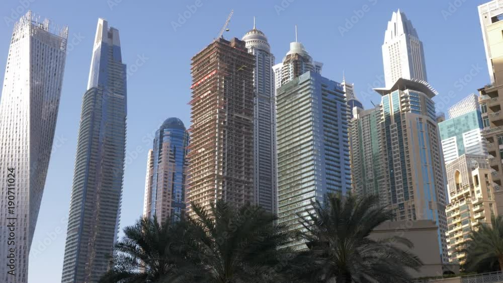 City landscape modern glass skyscrapers and palm trees in Dubai Marina City landscape modern glass skyscrapers and palm trees in Dubai Marina