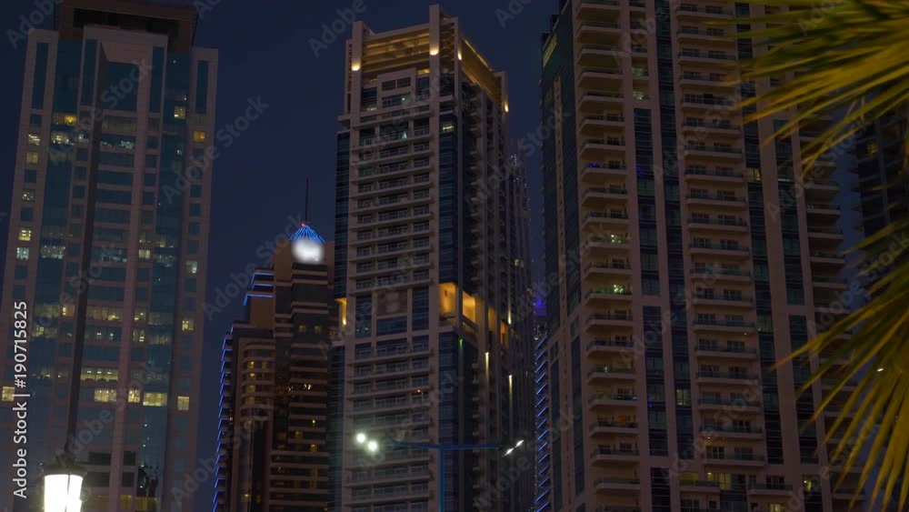 Night lighting in modern glass skyscrapers in evening Dubai city in UAE Night lighting in modern glass skyscrapers in evening Dubai city in UAE