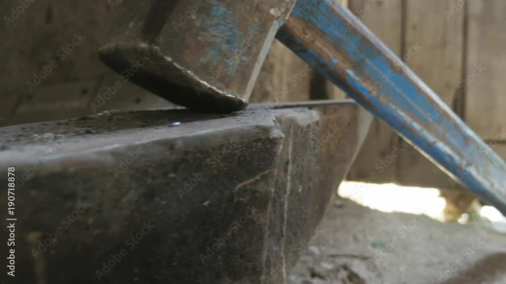 View of blacksmith hammer resting on anvil.
View of blacksmith hammer resting on anvil.