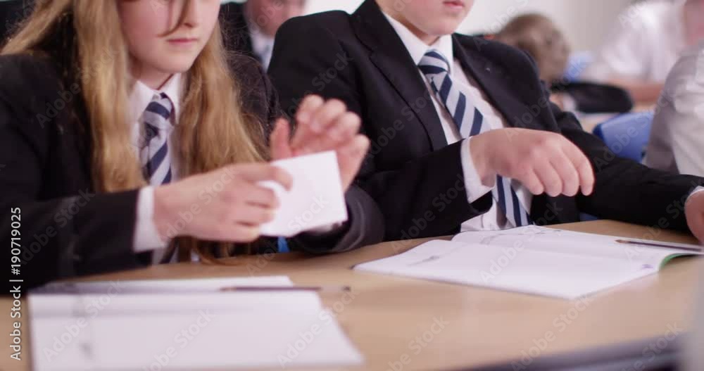 4k, Two students passing notes during a class. 4k, Two students passing notes during a class.
