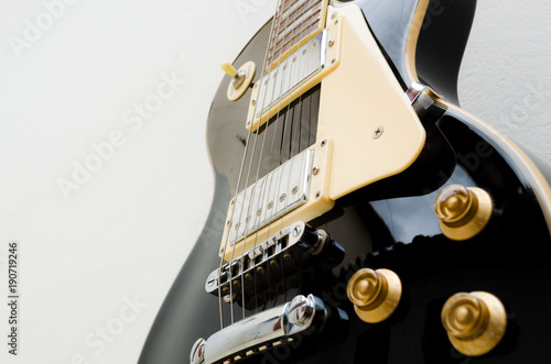 black guitar model les paul on a white background showing part of the body in a bottom and close view  photo