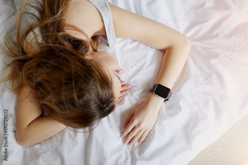 Obraz na plátne woman sleeping at white bed tracking function on smartwatches information on deep fitful sleep