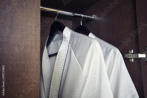 White bathrobe with hanger in wardrobe at hotel room