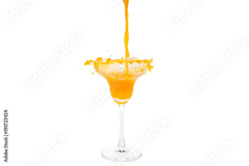 orange juice pouring in glass isolated on white background