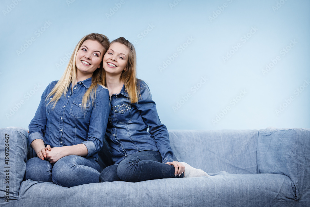 Two happy women friends wearing jeans outfit poitning Two happy women friends wearing jeans outfit poitning