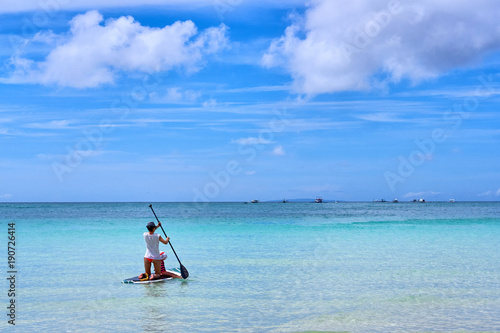 Woman is enjoying a view in standup paddleboarding over the ocean © Alexey Pelikh