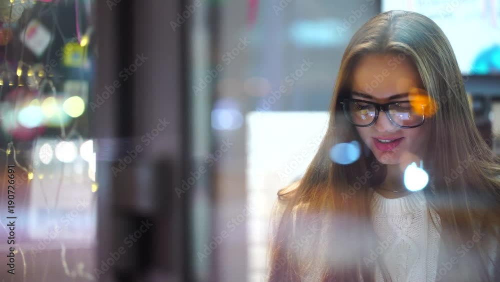 young sexy girl using tablet in cafe in evening in city, smilling. 4 k young sexy girl using tablet in cafe in evening in city, smilling. 4 k