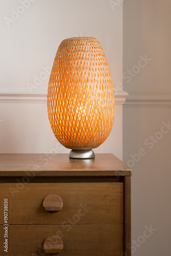 Photos Retro-styled Wicker Table Lamp on a Wooden Drawer