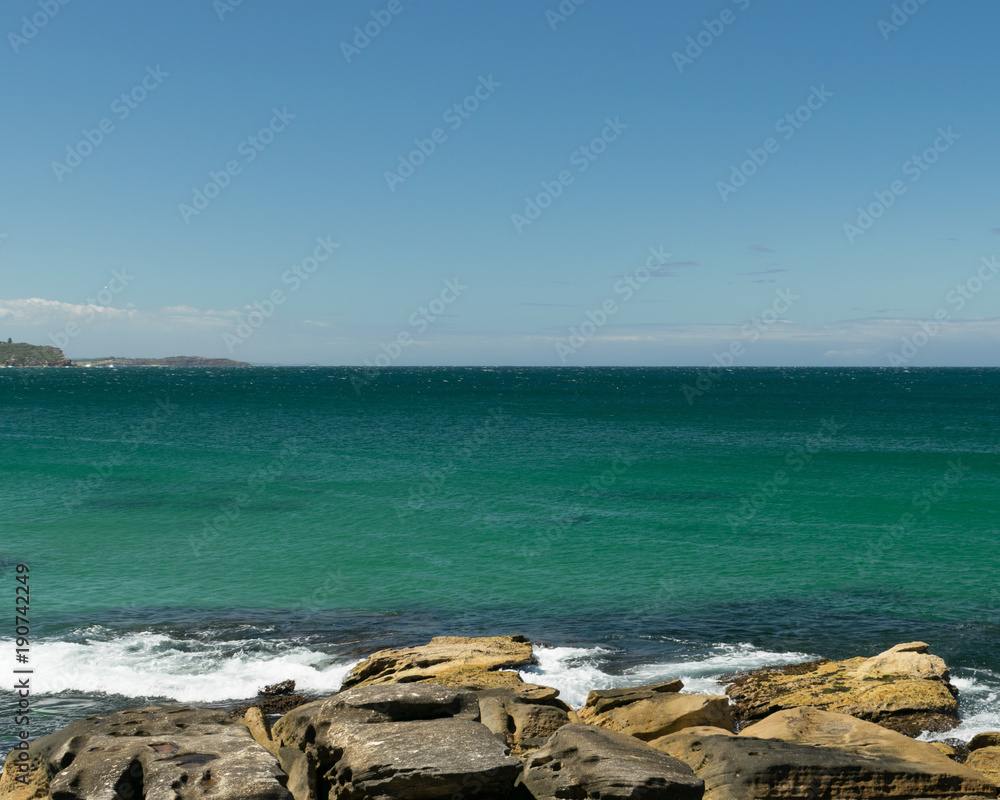 Rocks on the beach with horizon in the background - Manly Beach, Sydney, Australia