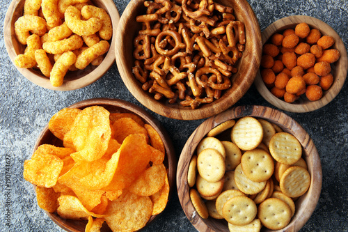 Fotótapéta Salty snacks. Pretzels, chips, crackers in wooden bowls.