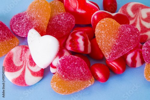 Heart shaped rubber candies on blue background