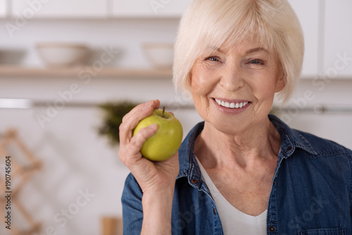 Close up a senior woman holding an apple