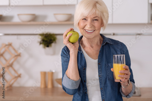 Cheerful elderly woman having a healthy breakfast photo