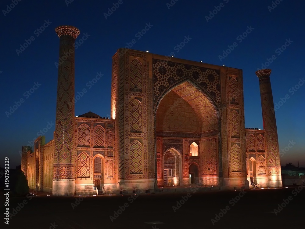 facade view with classic uzbek tiles and islamic mosaics of Ulughbek Madrassah, sunset in Registan Square, Samarkand, Uzbekistan