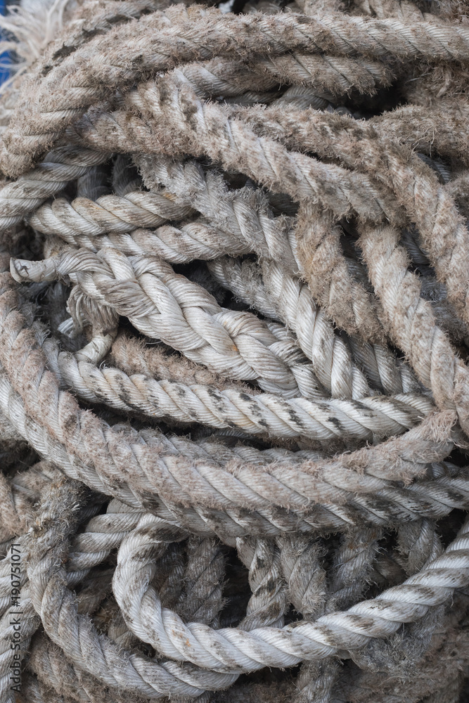 Old twisted rope bundle at sea port; close-up
