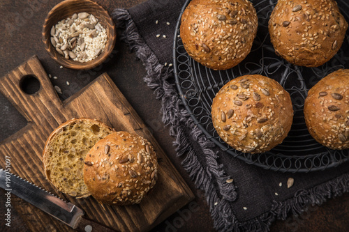 fresh baked buns with sesame, sunflower and flaxseed, wooden background