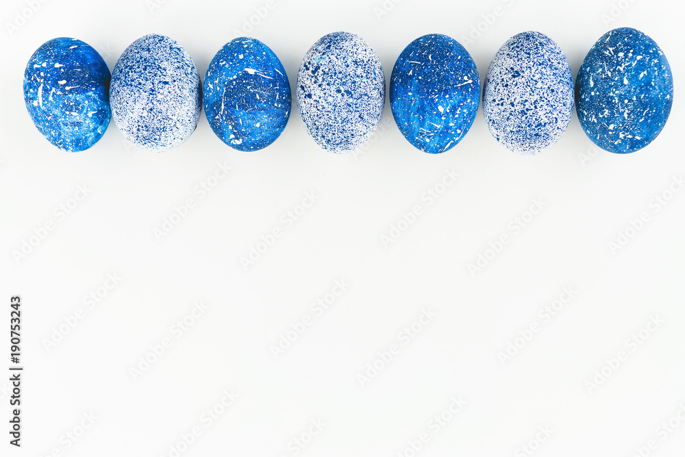 Blue Speckled Easter Egg with copy space for text on white background. Flat lay. Top view Blue Speckled Easter Egg with copy space for text on white background. Flat lay. Top view