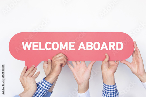 Group of people holding the WELCOME ABOARD written speech bubble photo