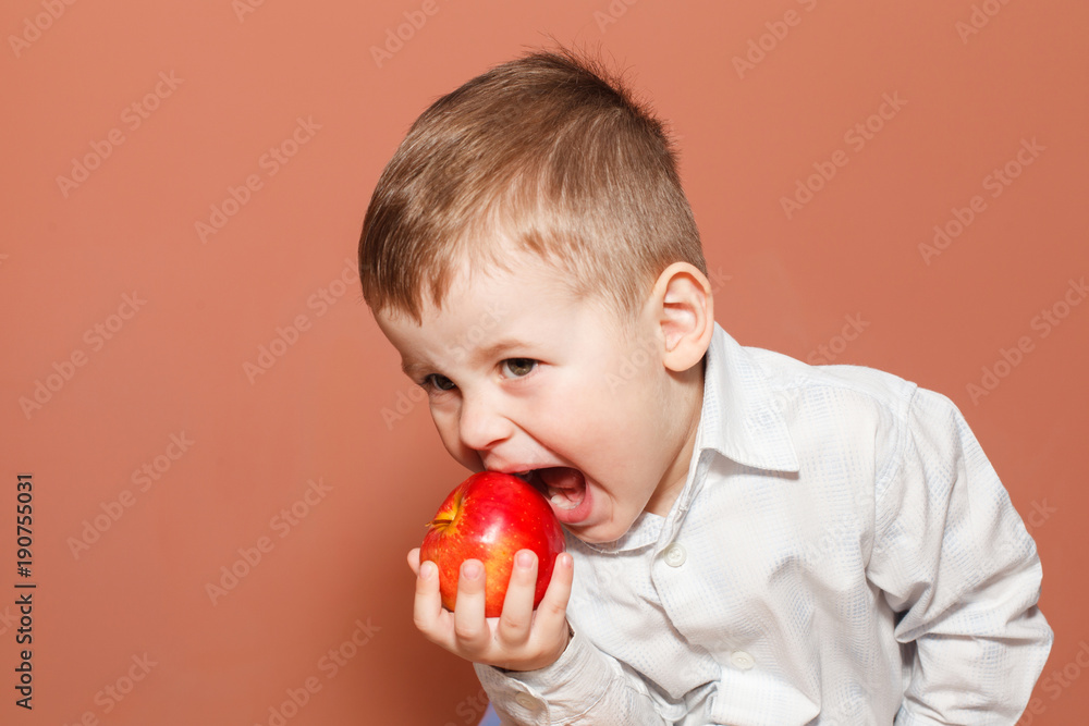 Active little boy eating red apple. Healthy Eating Active little boy eating red apple. Healthy Eating