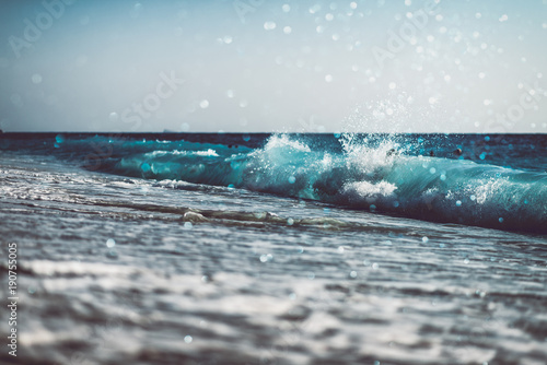 background of blurred beach and sea waves with bokeh lights
