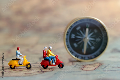 Miniature people: Traveller riding a motorcycle on map with compass, Concept of Travel around the world and the adventure.