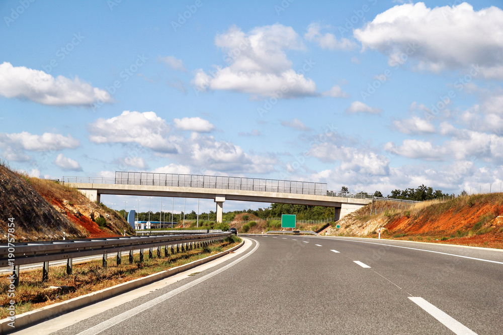 Scenic view on overpass and highway road leading through in Croatia, Europe / Beautiful natural environment, sky and clouds in background / Transport and traffic infrastructure / Signs and signaling.