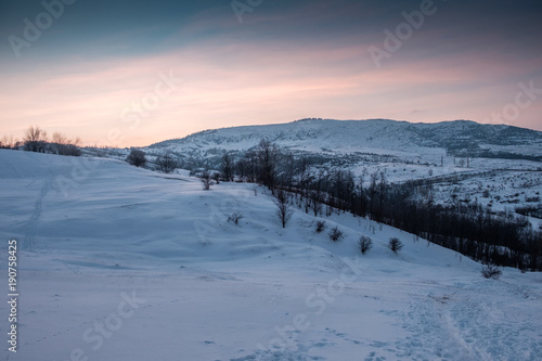 snowy hill at colorful sunset