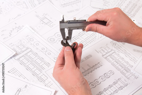 Technical drawing, caliper and driving roller chain. Engineering, technology and metalworking. Caliper measurement of detail of industrial chain. photo