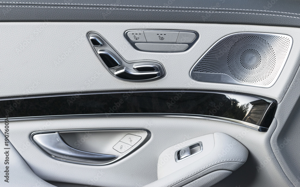 Door handle with Power seat control buttons of a luxury passenger car. White leather interior of the luxury modern car. Modern car interior details
