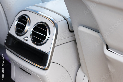 AC Ventilation Deck Luxury Car Interior. Modern car interior details white leather, natural wood.