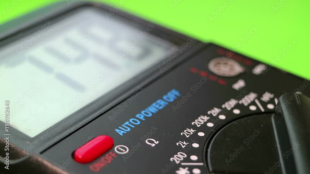 Multimeter close-up on a green background. Mode dial. Power button. The man is measuring. Full HD video. Multimeter close-up on a green background. Mode dial. Power button. The man is measuring. Full HD video.
