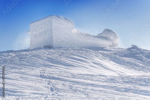 Snow caped Old observatory at the summit of mountain Pip Ivan (2026 m) in Chernogora mountain chain of Ukrainian Carpathian mountains. Winter scenery.