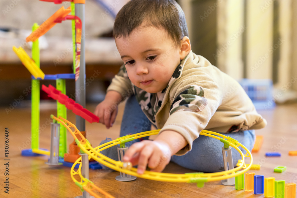 baby boy is played with a creative multi-colored toy baby boy is played with a creative multi-colored toy