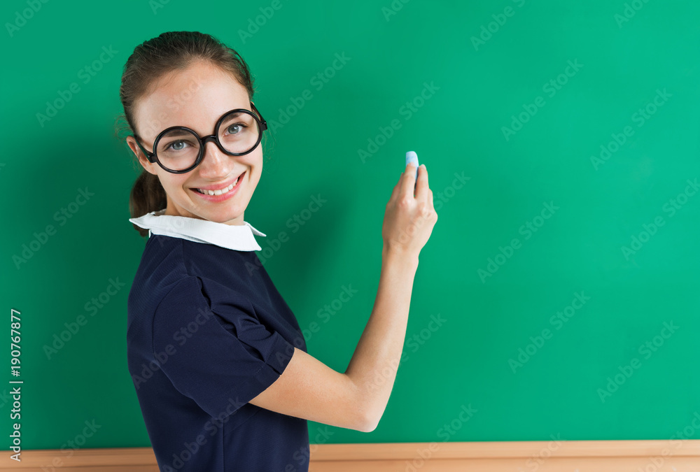 Young student writing on blackboard. Photo of teen near blackboard, education concept Young student writing on blackboard. Photo of teen near blackboard, education concept