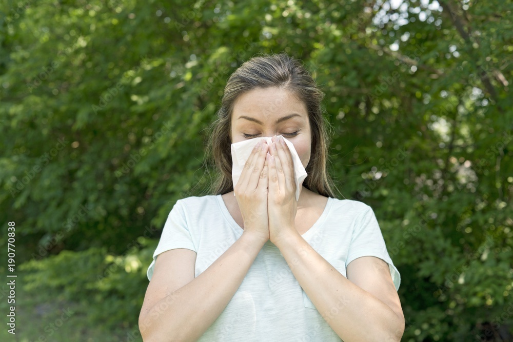 Woman blowing her nose on a tissue Woman blowing her nose on a tissue