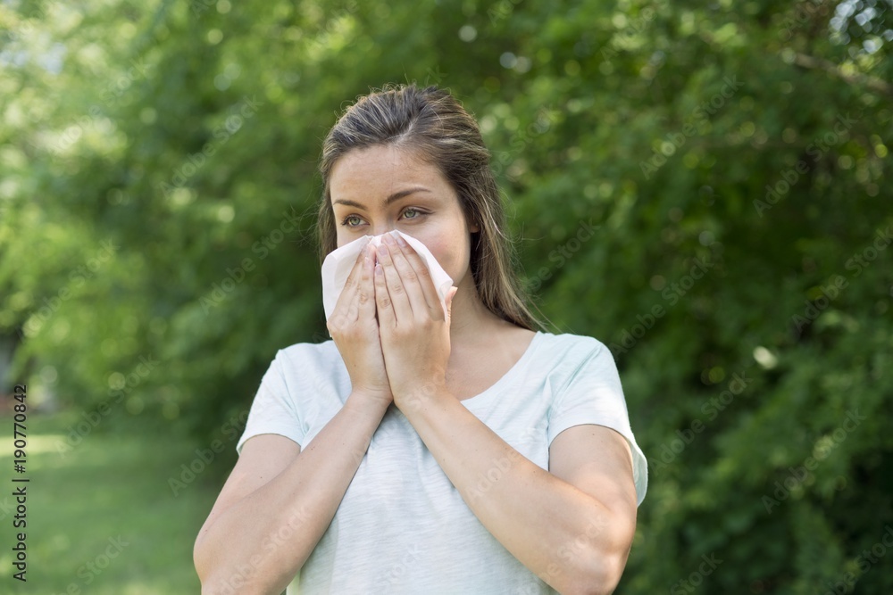 Woman blowing her nose on a tissue Woman blowing her nose on a tissue