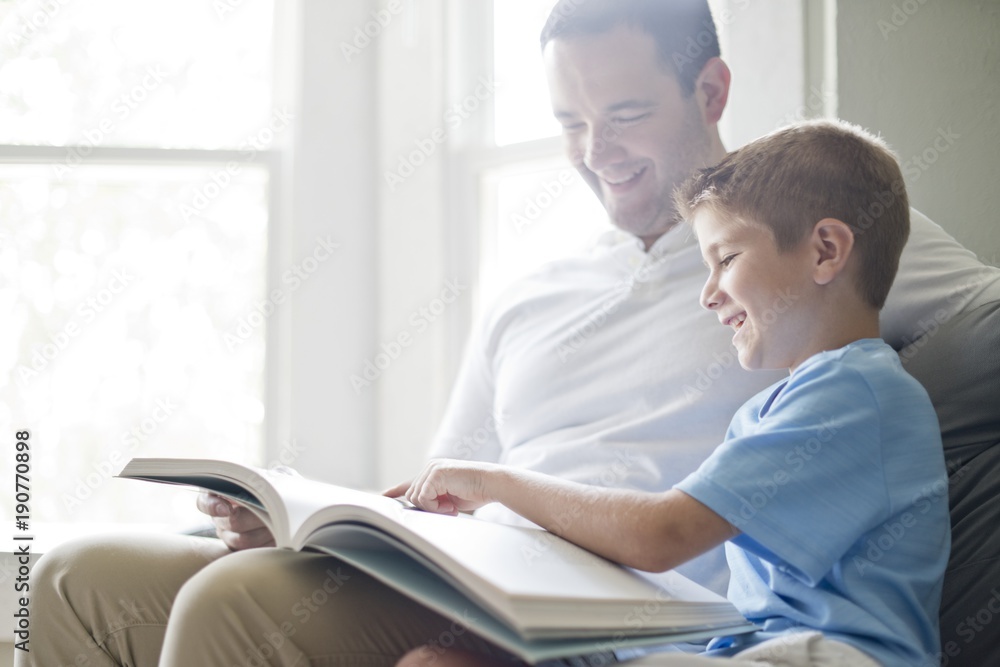 Boy reading book with his father Boy reading book with his father